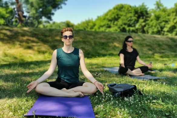 A picture of a fitness group happening in the outdoors with trees and grass in the background.