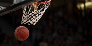 A basketball going through a basketball net.